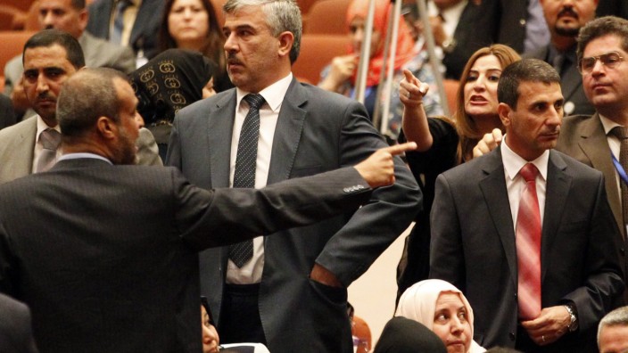 Members of the newly elected Iraqi parliament point fingers after an argument broke out at the parliament headquarters in Baghdad
