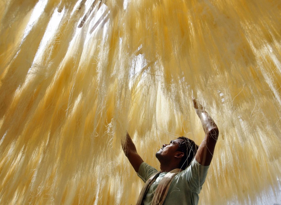 A man arranges strands of vermicelli, which are kept for drying at a factory in Allahabad