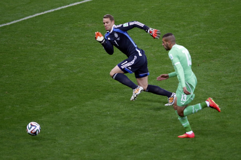 Germany's goalkeeper Neuer challenges Algeria's Slimani during their 2014 World Cup round of 16 game at the Beira Rio stadium in Porto Alegre