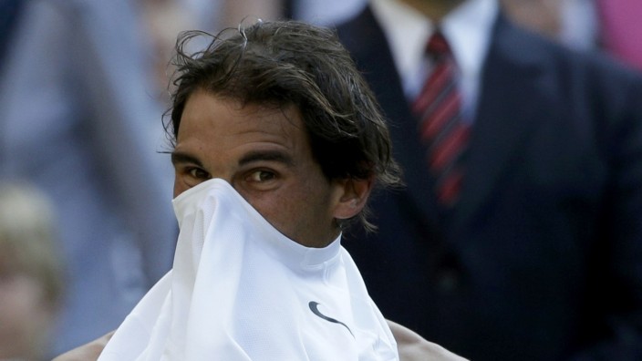 Rafael Nadal of Spain pulls his shirt over his face during his men's singles tennis match against Nick Kyrgios of Australia at the Wimbledon Tennis Championships, in London