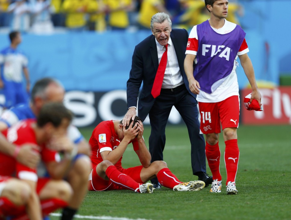 Switzerland's coach Ottmar Hitzfeld consoles his players after they lost to Argentina in their 2014 World Cup round of 16 game at the Corinthians arena in Sao Paulo