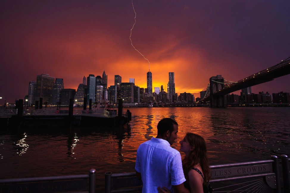 Joseph Rojas and Abigail Zolotarsky embrace as lightning strikes One World Trade Center in Manhattan