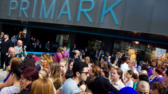 People line up outside a store of clothing retailer Primark before its opening in Berlin