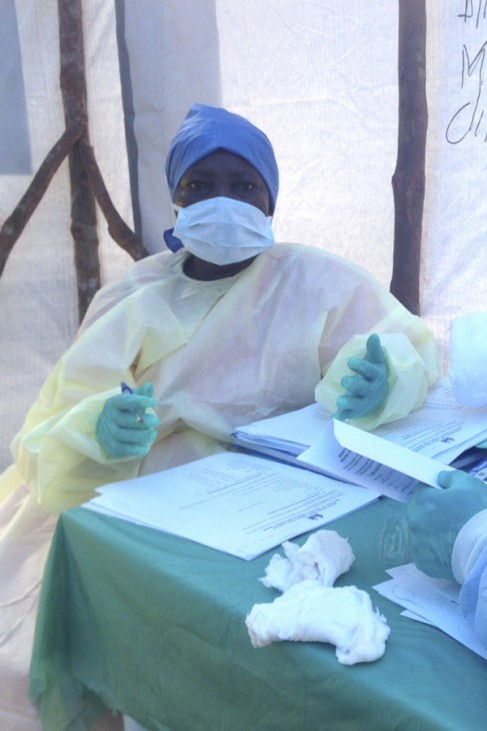 Government health workers are seen during the administration of blood tests for the Ebola virus in Kenema