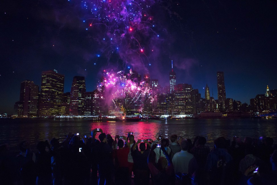 Spectators watch Macy's Fourth of July fireworks explode over the East River in New York