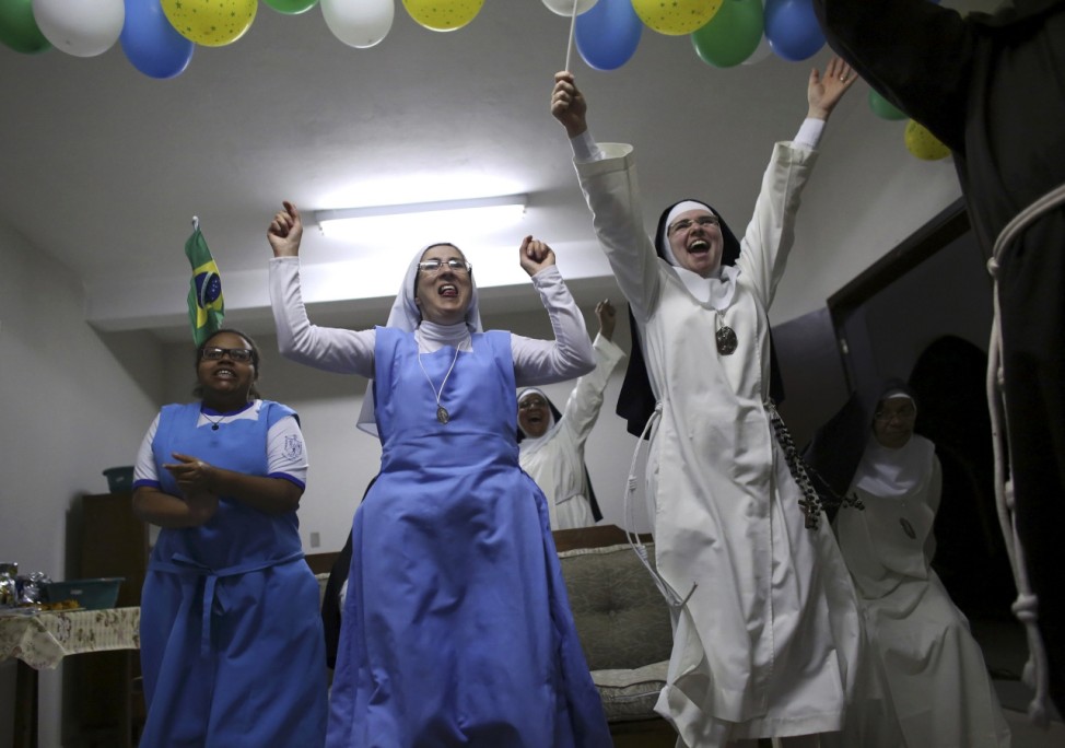 Nuns from the enclosed monastery of Imaculada Conceicao, celebrate their victory at the end of the 2014 World Cup quarter-final soccer match between Brazil and Colombia in Piratininga