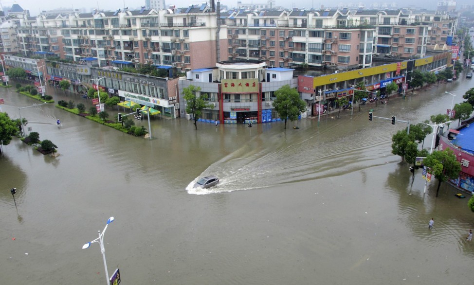 A car travels on a flooded street after heavy rainfalls hit Ruichang