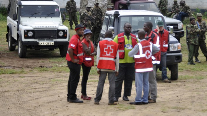 Terror an der Küste Ostafrikas: Sicherheitskräfte und MItarbeiter des kenianischen Roten Kreuzes stehen im Küstenort Gamba, wo Bewaffnete in der Nacht mindestens neun Menschen töteten.