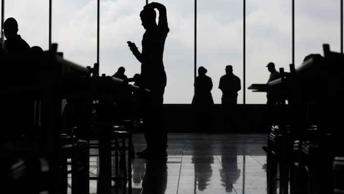 Menschen mit Smartphones warten am Curitiba Airport, Brasilien