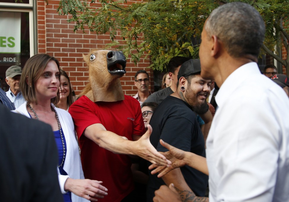 U.S. President Obama greets man wearing a horse mask during a walkabout in Denver