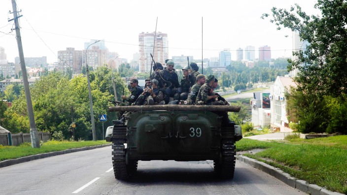 Pro-Russian separatist fighters from the so-called Battalion Vostok (East) travel on an armoured vehicle in Donetsk