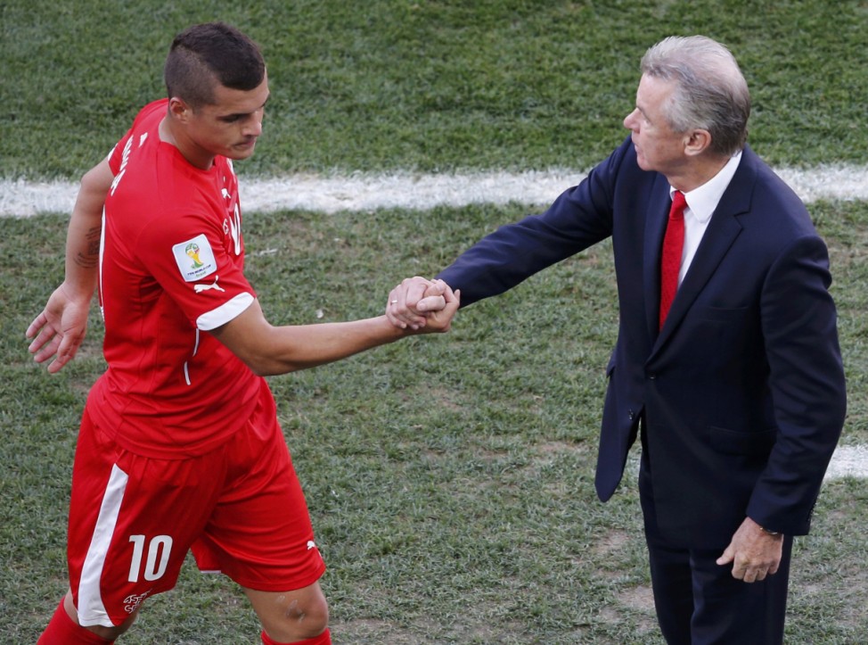 Switzerland's Xhaka exchanges handshakes with coach Hitzfeld during their 2014 World Cup round of 16 game at the Corinthians arena in Sao Paulo