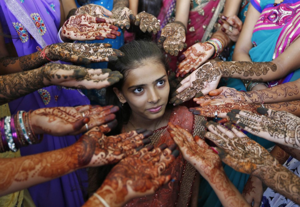 Schoolchildren show their hands decorated with henna paste during a henna competition to mark World Population Day in the western Indian city of Ahmedabad
