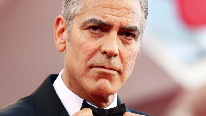 U.S. actor Clooney adjusts his bowtie as he arrives for the premiere of 'Gravity' at the 70th Venice Film Festival