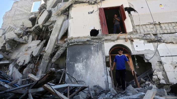 Neuer Gaza-Krieg: Palästinenser laufen durch die Trümmer eines Gebäudes in Gaza-Stadt, das bei einem israelischen Luftangriff am Freitag zerstört worden ist.