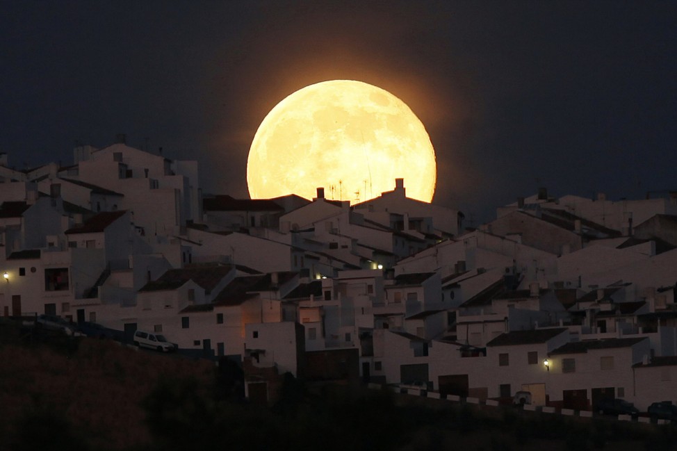 The Supermoon rises over houses in Olvera