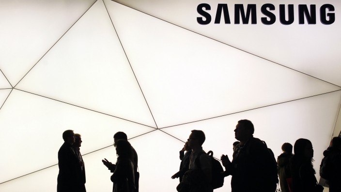 People walk past a Samsung stand at the Mobile World Congress in Barcelona