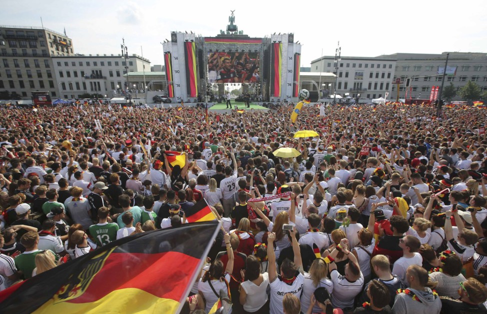 German soccer fans cheer as they wait for the arrival of their team, winners of the 2014 World Cup, near the Brandenburg Gate in Berlin