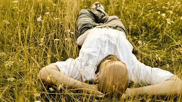 Mann liegt im Gras