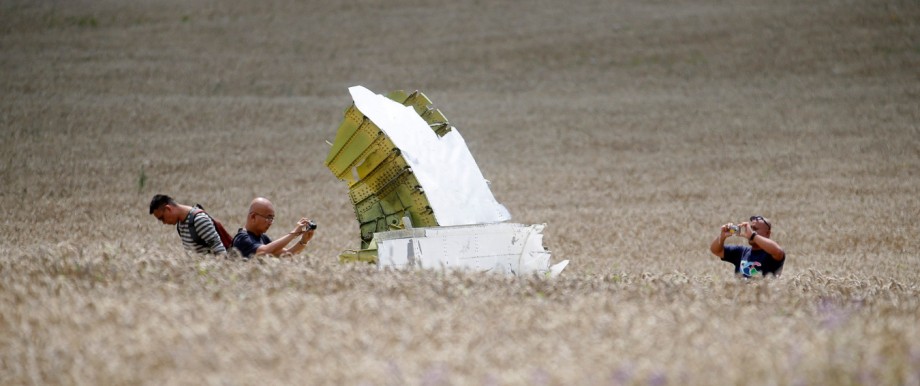 Malaysian air crash investigators take photos of the crash site of Malaysia Airlines Flight MH17