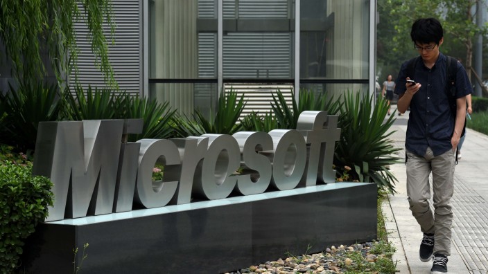 US-Gerichtsentscheid: Ein Mann geht am Firmenzeichen von Microsoft in Peking vorbei. Der Internetkonzern muss US-Ermittlern auch Daten aus Europa liefern.