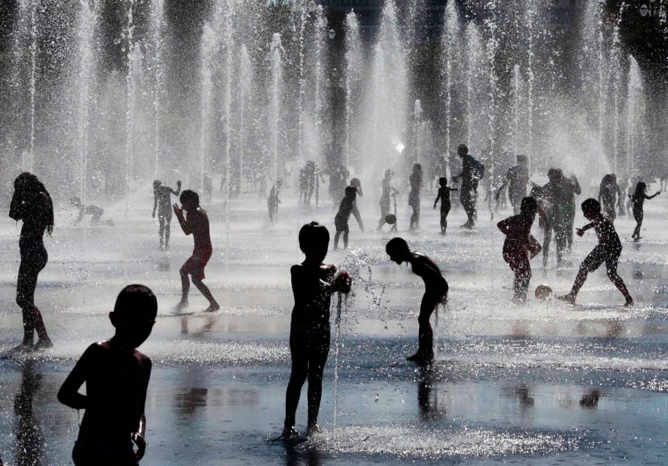 Children play in a fountain during a hot and sunny summer day in Nice