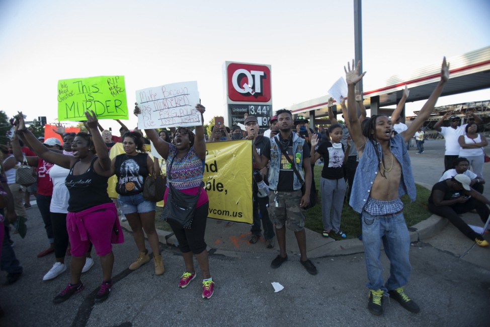 Demonstrators raise their hands while protesting the shooting death of teenager Michael Brown, in Ferguson, Missouri