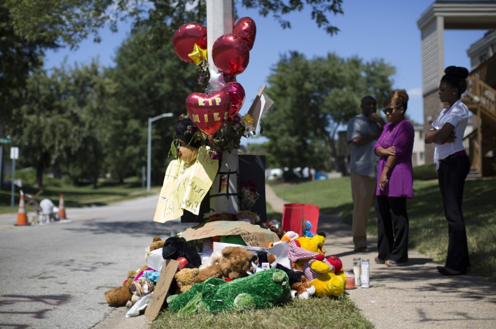 People gather by a makeshift memorial near the site where Brown was shot to death in Ferguson, Missouri