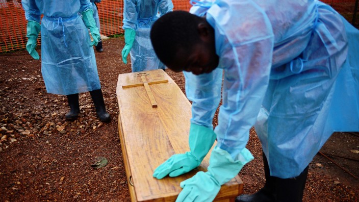 Weltgesundheitsorganisation WHO: Eine Gruppe Bestatter schützt sich in Sierra Leone mit Schutzkleidung vor dem Ebola-Virus.