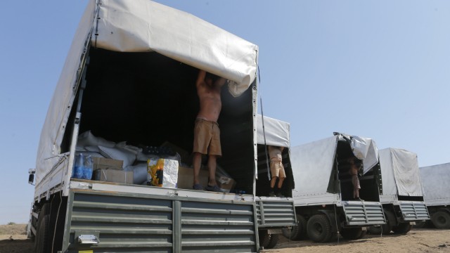 Drivers of a Russian convoy of trucks carrying humanitarian aid for Ukraine show the contents of their trucks at a camp near Kamensk-Shakhtinsky
