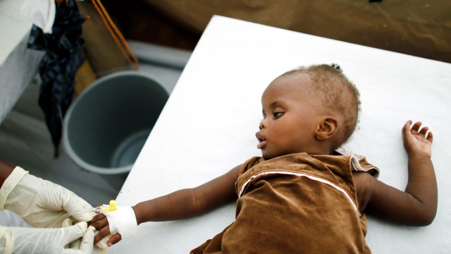 A Haitian girl receives an intravenous drip at a cholera treatment center in Port-au-Prince