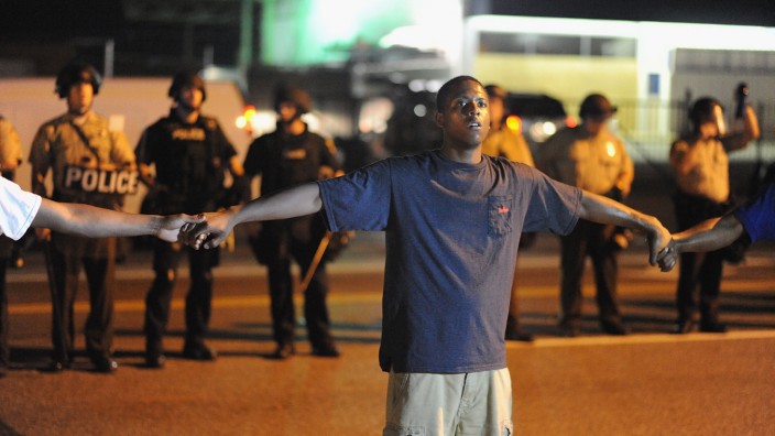 Tod von Michael Brown: Einige Demonstranten in Ferguson bilden eine Menschenkette, um aggressive Protestierende und Polizisten voneinander zu trennen.