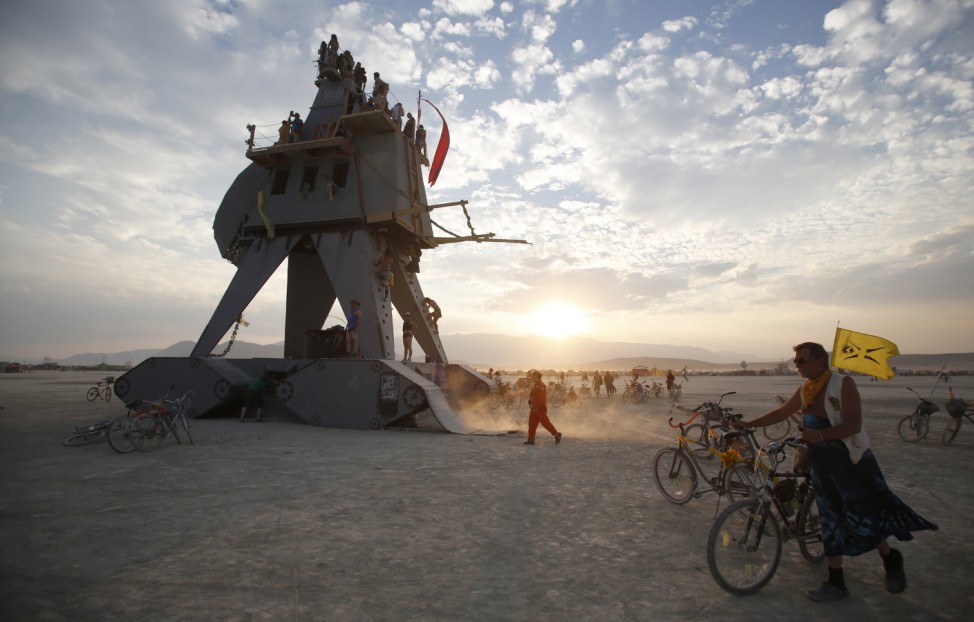 Participants interact with the Alien Siege Machine during the Burning Man 2014 'Caravansary' arts and music festival in the Black Rock Desert of Nevada