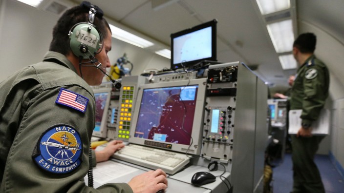 A controller sits at screens aboard NATO AWACS aircraft during surveillance flight over Romania from AWACS air base in Geilenkirchen