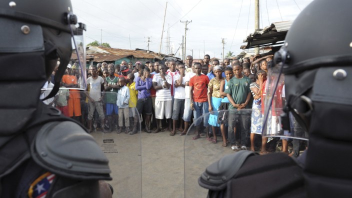 Liberian security forces stand in front of protesters after clashes at West Point neighbourhood in Monrovia