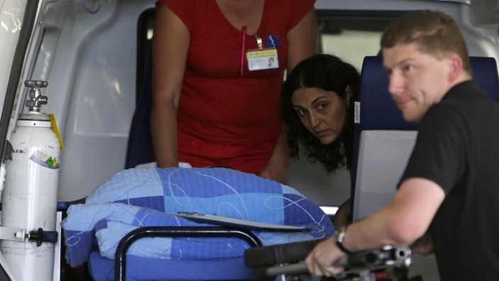 King looks as her son Ashya King, a 5-year-old British boy with a brain tumour, is transported on a stretcher upon arriving at the Motol hospital in Prague