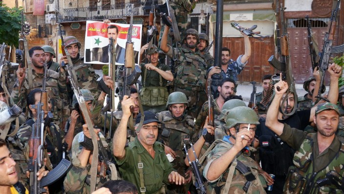 Internationale Allianz gegen IS: Bald könnte die Isolation für sie vorbei sein: Soldaten der syrischen Armee mit einem Poster ihres Präsidenten al-Assad.