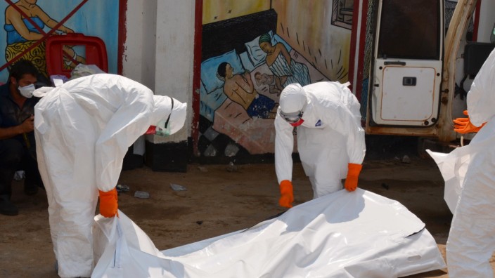 Epidemie in Westafrika: Mitarbeiter des Liberianischen Roten Kreuzes decken eine Leiche mit einer Plane ab.