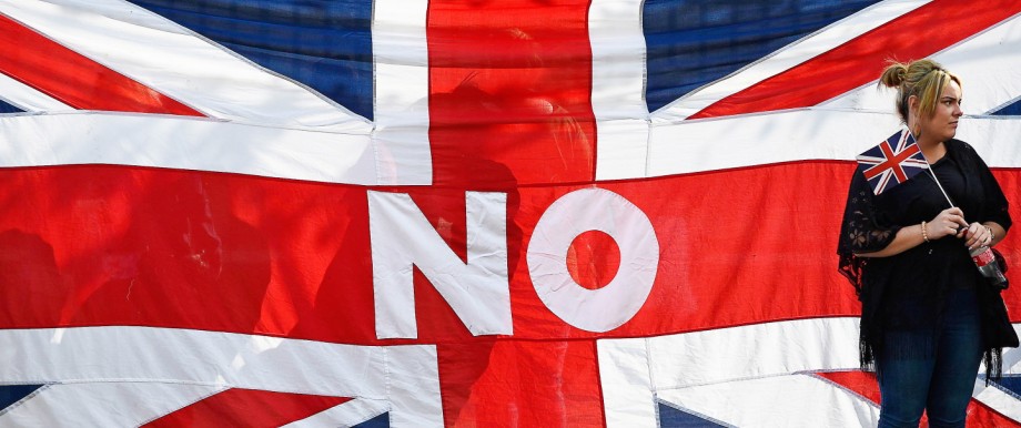 A woman stands by a Union flag as she watches a pro-Union rally in Edinburgh, Scotland