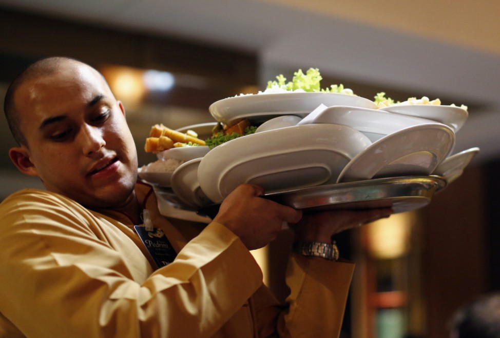 Waiter carries plates in 'Pedrini' restaurant in Porto Alegre