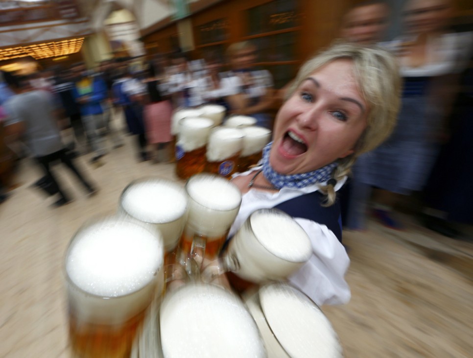Waitress carries mugs of beer during opening day of the 181st Oktoberfest in Munich