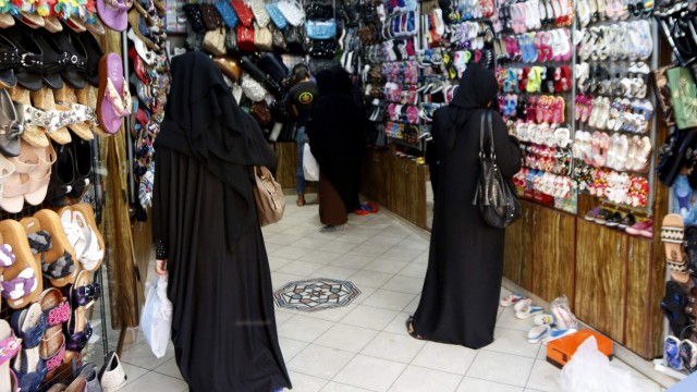 Women look at shoes inside a shop in Raqqa