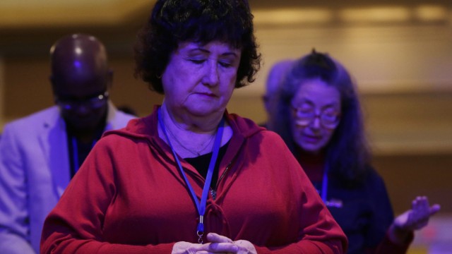 Attendees bow their heads in prayer at the morning plenary session of the Values Voter Summit in Washington
