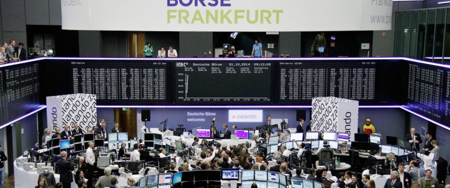 Visitors stand in front of the DAX board at the Frankfurt stock exchange