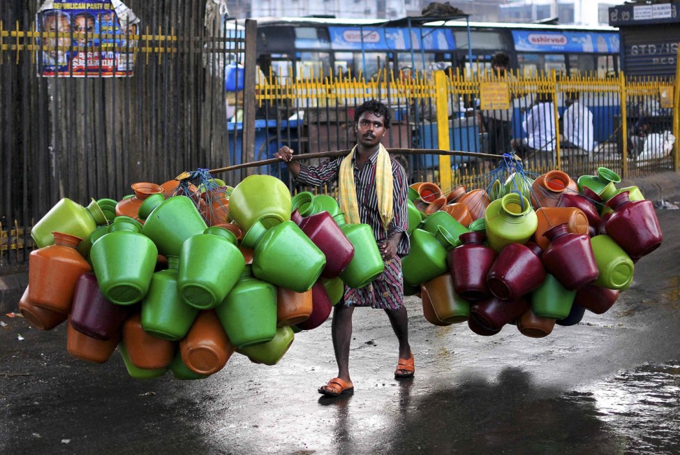 A man carries empty water pitchers for sale in a market in the southern Indian city of Bangalore