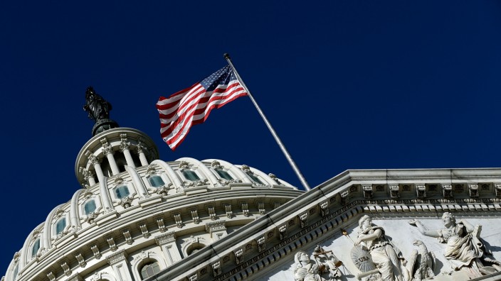 Congress Gridlocked Over Continuing Resolution Legislation WASHINGTON, DC - SEPTEMBER 29: An American flag waves outside the United States Capitol building as Congress remains
