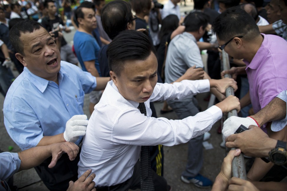 A office worker rushes to join pro-democracy protesters as they attempt to reinforce their barricades, as anti-Occupy Central protesters try to remove the road blocks, in the Central financial district in Hong Kong