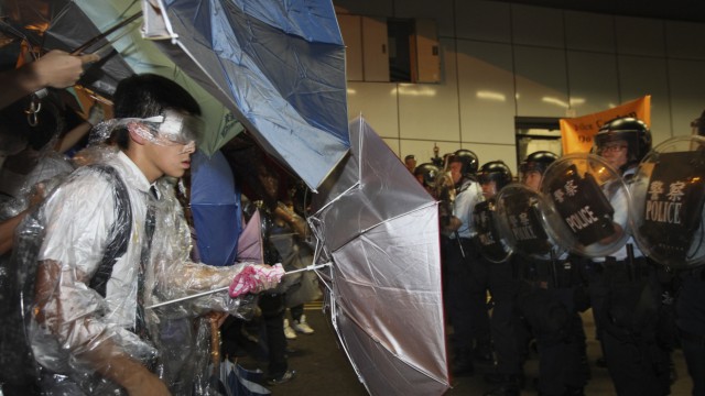 A student protester in his school uniform stands off with riot police inside a vehicle tunnel as pro-democracy protesters stormed in to block a road leading to the financial Central district in Hong Kong