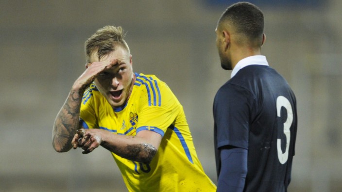 Sweden's Guidetti celebrates after a team mate scored as France's Kurzawa looks on during their UEFA U21 European Championships qualifying soccer match at Orjans Vall in Halmstad