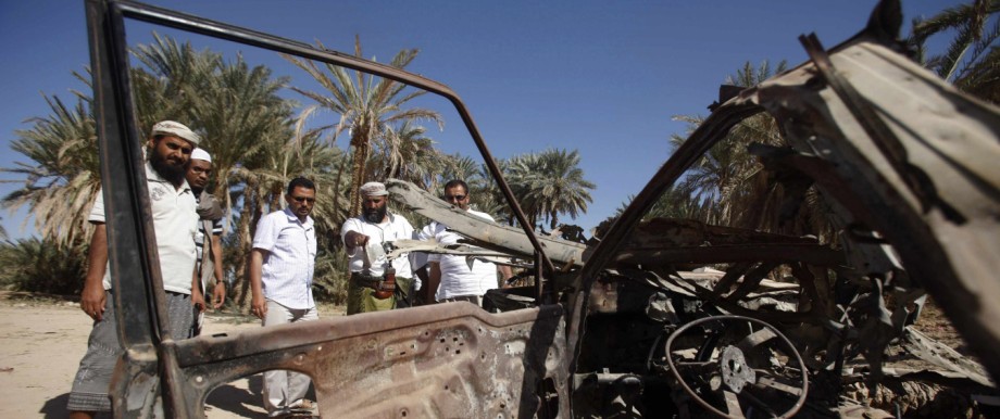 People talk to human rights activists next to debris left by a U.S. drone air strike that targeted suspected al Qaeda militants in August 2012, in the al-Qatn district